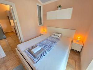 a large white bed in a room with two lights at Villa Dvojac Holiday house with Jacuzzi and grill in Jadranovo