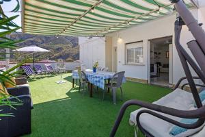 a patio with a table and chairs on the grass at A due passi dal mare in Oliveri