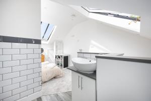 a white bathroom with a sink and a bedroom at Stylish 2BR Cottage in Chesham in Chesham +36 photos