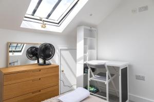 a attic room with a desk and a skylight at Stylish 2BR Cottage in Chesham in Chesham