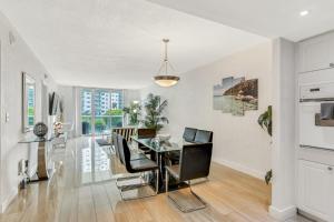 a dining room with a glass table and chairs at Luxury Miami Condos - 1BR-2BR & 3BR in Miami Beach