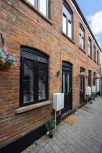 a brick building with black doors and windows at Stylish 2BR Cottage in Chesham in Chesham
