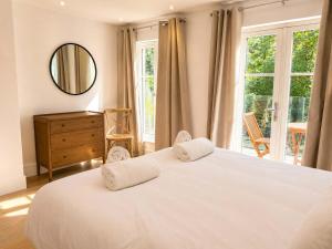 a bedroom with a large white bed and a mirror at Watersmeet Point in Lynmouth