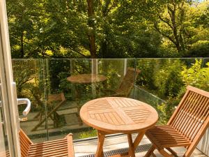 a wooden table and two chairs on a balcony at Watersmeet Point in Lynmouth