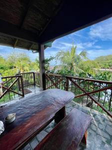 a wooden table on a balcony with a view of the ocean at Jardin Secreto in El Viejo
