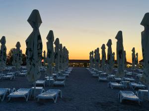 a group of chairs and umbrellas on a beach at Blaxy del Mar Studio Olimp in Olimp