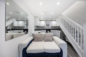 a white room with a couch in the middle of a kitchen at Stylish 2BR Cottage in Chesham in Chesham