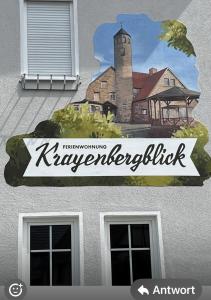 a sign on the side of a building with a painting at Ferienwohnung Krayenbergblick 1 in Bad Salzungen