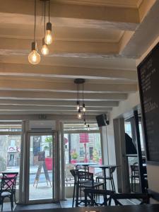 a dining room with tables and chairs and lights at Hôtel Bar Restaurant La Terrasse in Larche
