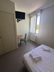 a bedroom with a bed and a chair and a window at Hôtel Bar Restaurant La Terrasse in Larche
