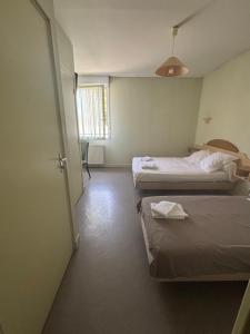 a hotel room with two beds and a window at Hôtel Bar Restaurant La Terrasse in Larche