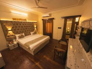 a bedroom with a large bed and a table at The Amber House - Luxury Boutique Stay in Bani Park, City Center Jaipur in Jaipur
