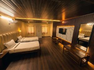 a hotel room with two beds and a television at The Amber House - Luxury Boutique Stay in Bani Park, City Center Jaipur in Jaipur