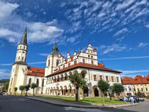 a large white building with two towers on a street at Hikeslovakia House in Mlynčeky