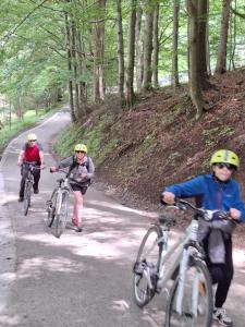three people riding bikes down a road at Hikeslovakia House in Mlynčeky