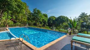 a large swimming pool with blue water and trees at Ting Rai Bay Resort in Ko Jum