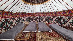 two beds in a room with a wall with patterns at Emin Sky Camp in Mineralʼnyy Istochnik Altyn-Arasan