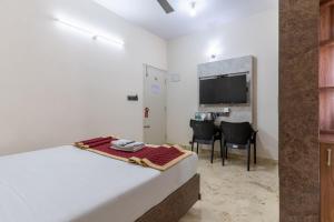 a hotel room with a bed and a television at Hotel metro grand in Bangalore +8 photos