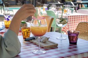 a person sitting at a table with a drink at Brit Hotel Angers Parc Expo - L'Acropole in Saint-Sylvain-dʼAnjou