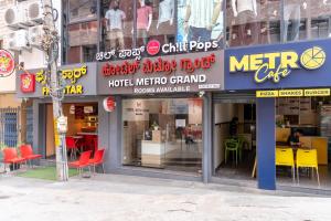 a store front of a restaurant with red chairs at Hotel metro grand in Bangalore