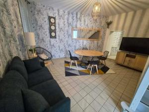 a living room with a couch and a table at Petunia in Commentry