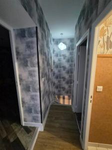 a hallway with a room with a stone wall at Petunia in Commentry