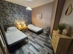 a room with two beds and a table and a chair at Petunia in Commentry