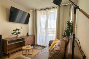 a living room with a couch and a large window at Vista Laguna Oriente By Andes Plus in Concepción