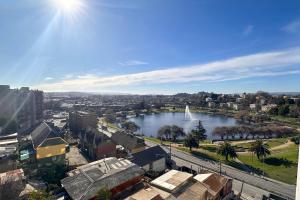 a view of a river with a sail boat in a city at Vista Laguna Oriente By Andes Plus in Concepción