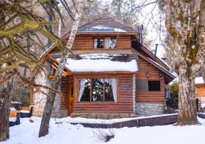 a log cabin with snow on the roof at Ruma Andina by DOT Cabana in Villa La Angostura