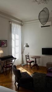 a living room with a table and chairs and a lamp at La Maison des Courtines in Beaune