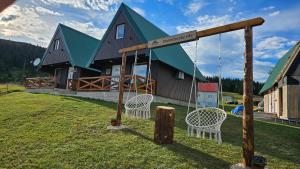 a house with a swing in front of it at Durmitorske Vile in Žabljak
