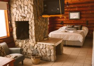 a bedroom with a bed and a stone fireplace at Ruma Andina by DOT Cabana in Villa La Angostura