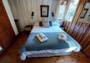a bedroom with a bed with towels on it at Ruma Andina by DOT Cabana in Villa La Angostura