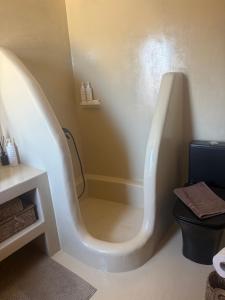 a white bath tub in a bathroom with a toilet at Stone Wave Kythnos in Loutra +22 photos