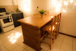 a kitchen with a wooden table and some chairs at Melvillas in Louis Trichardt