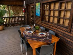 a wooden table with chairs and a table cloth on a porch at Moz Inn - Coconut View Resort in Lopes