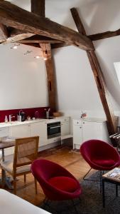 a kitchen with two red chairs and a table at La Maison des Courtines in Beaune