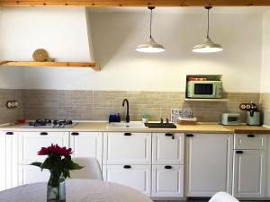 a kitchen with white cabinets and a microwave at Casa Charly in Almócita