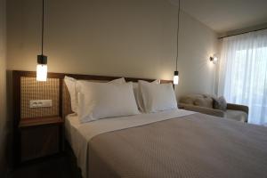 a bedroom with a large bed with white pillows at Phi Aegina in Agia Marina Aegina