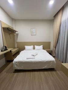 a bedroom with a large white bed in it at Luminara Villa Kuala Besut in Kampung Kuala Besut