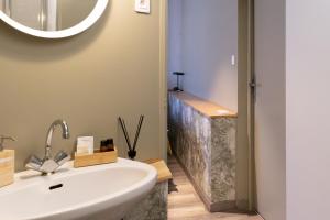 a bathroom with a white sink and a mirror at Hotel Linette in Aumont-Aubrac +18 photos