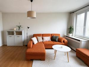 a living room with an orange couch and a table at Apartmán Malohont in Rimavská Sobota