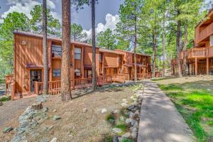 a log home in the woods with a path leading to it at Hike, Golf & Explore: Ruidoso Retreat w/ Deck! in Ruidoso