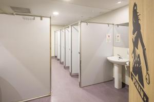 a row of stalls in a bathroom with a sink at UP Hostel Valencia in Valencia +47 photos