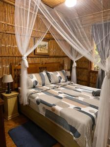 a bedroom with a bed with drapes at Moz Inn - Coconut View Resort in Lopes