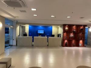 a large lobby with a blue wall and desks in it at MERCURE RECIFE NAVEGANTES · Flat Recife Navegantes - 50 metros da praia. in Recife