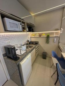 a small kitchen with a sink and a microwave at MERCURE RECIFE NAVEGANTES · Flat Recife Navegantes - 50 metros da praia. in Recife