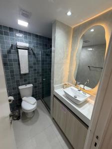 a bathroom with a toilet and a sink and a mirror at MERCURE RECIFE NAVEGANTES · Flat Recife Navegantes - 50 metros da praia. in Recife