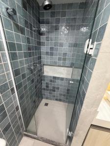 a bathroom with a shower with blue tiles at MERCURE RECIFE NAVEGANTES · Flat Recife Navegantes - 50 metros da praia. in Recife +40 photos